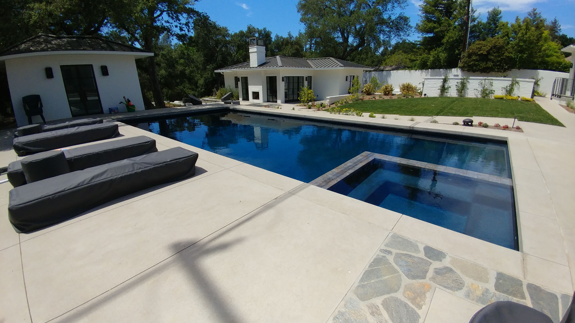 Modern dark bottom rectangular pool with a flush set spa