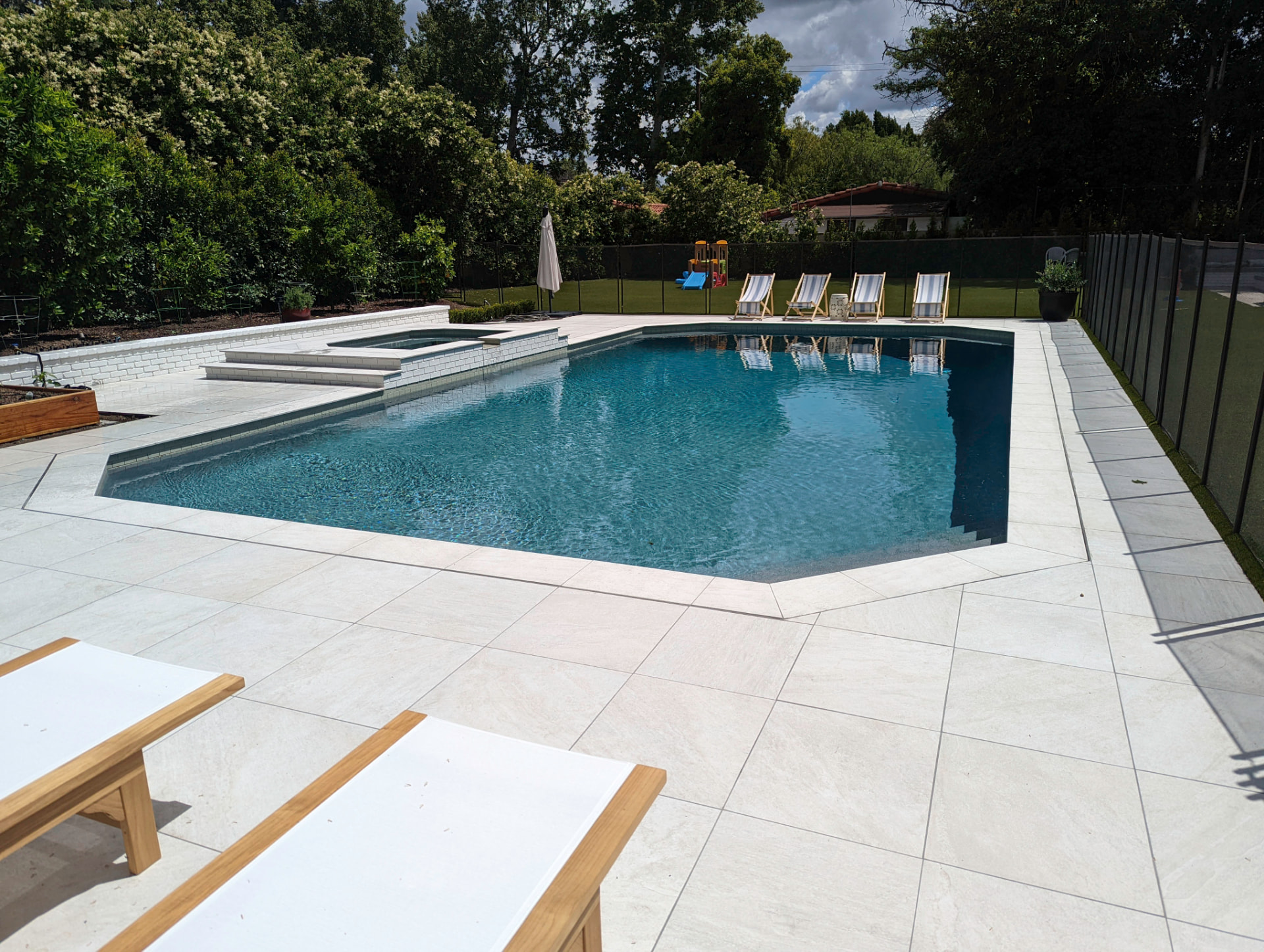 Modern geometric pool with a white brick raised spa wall