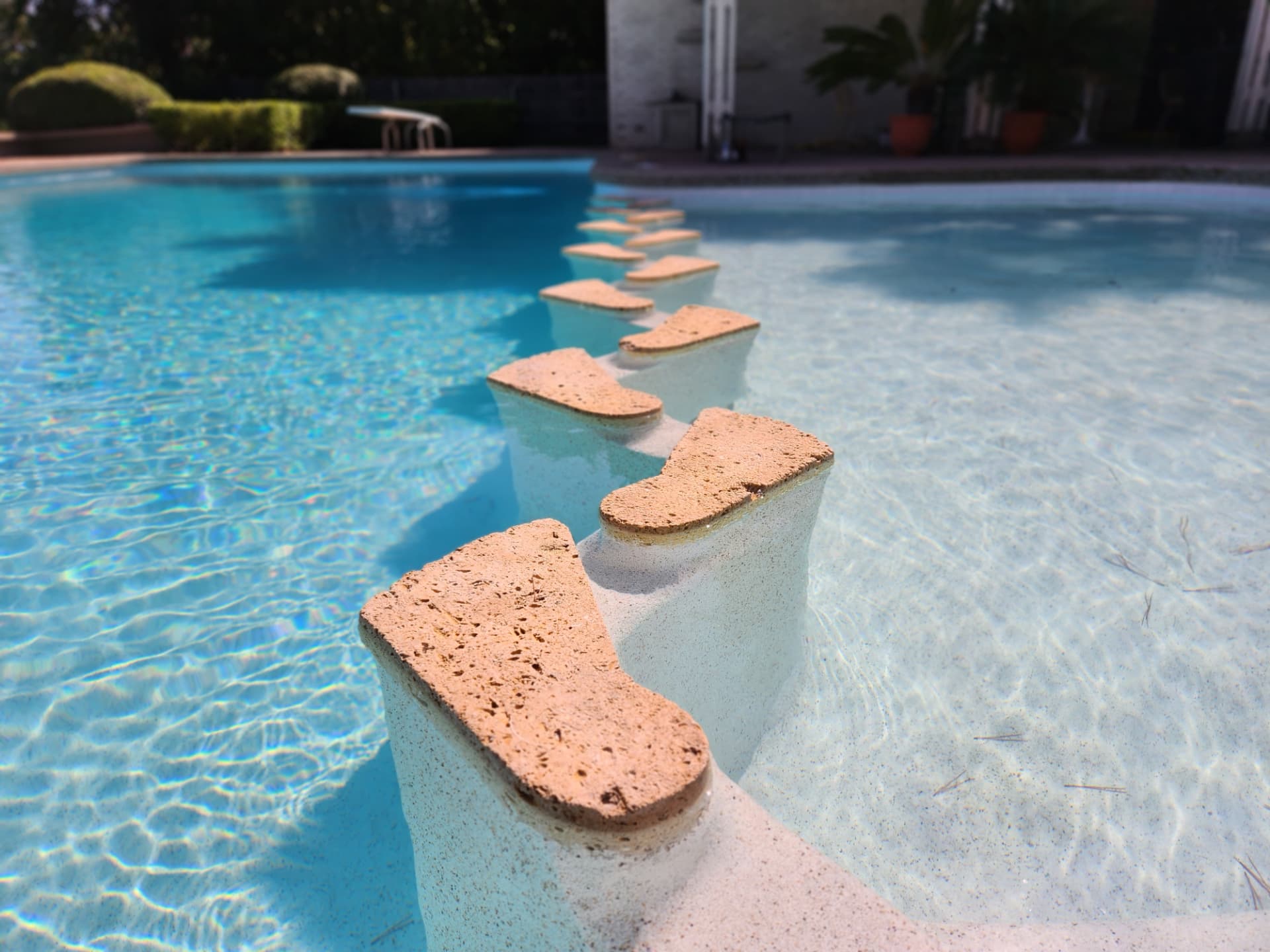 Custom travertine topped footstep entry into a swimming pool