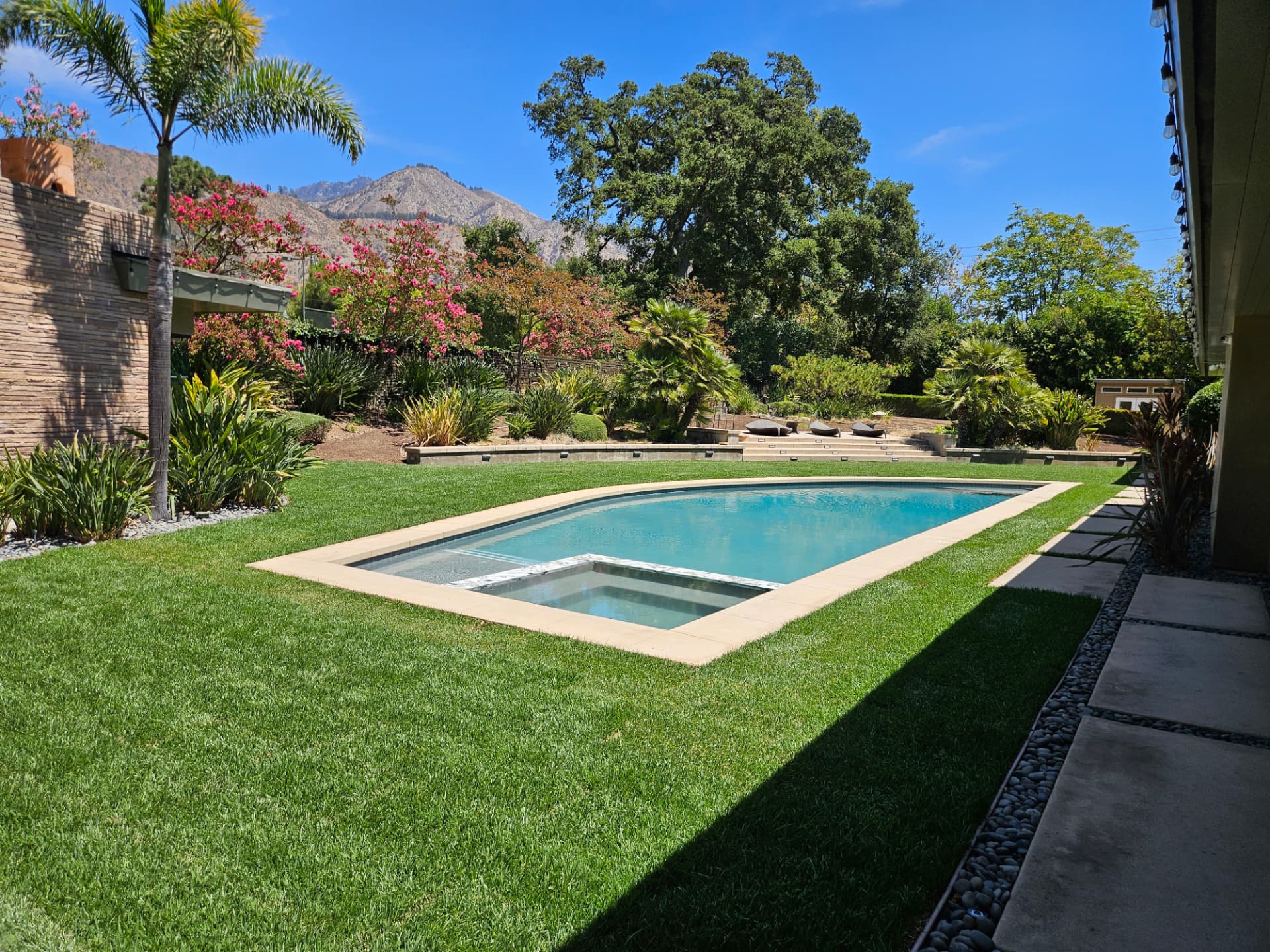 Sail shaped pool with integrated spa set in a green lawn