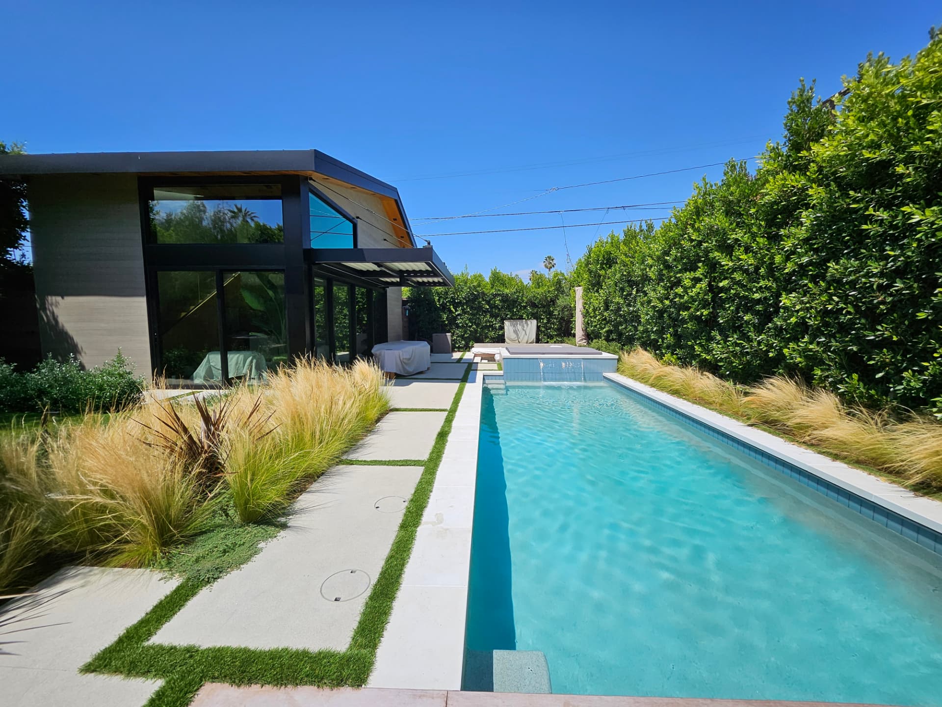 Contemporary lap pool with a sheer descent water feature